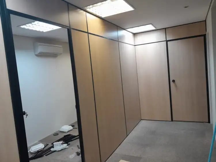 Sala montada com divisórias amadeiradas e perfis pretos