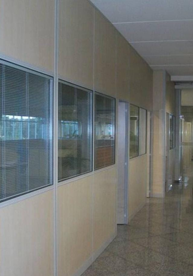 Corredor corporativo com divisórias e visores de vidro